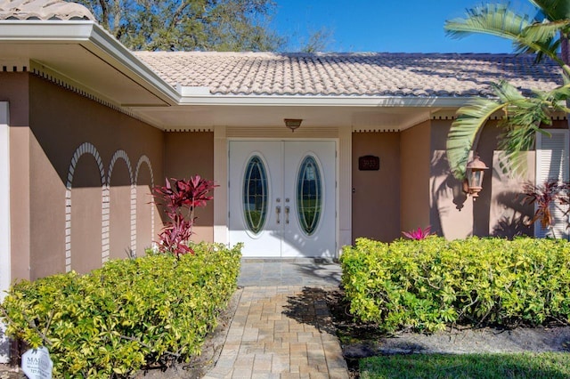 doorway to property with a tile roof and stucco siding