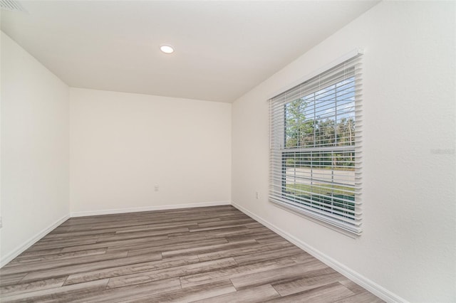 unfurnished room featuring visible vents, baseboards, wood finished floors, and recessed lighting