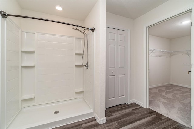 bathroom with a stall shower, recessed lighting, wood finished floors, and baseboards