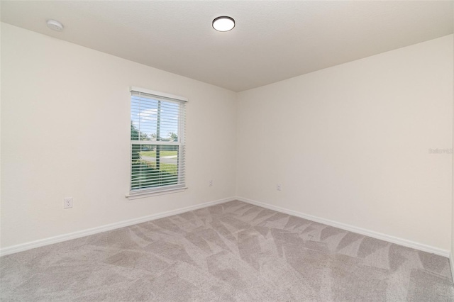 empty room with light carpet and baseboards