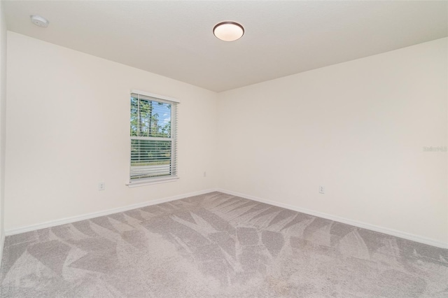 spare room with carpet and baseboards