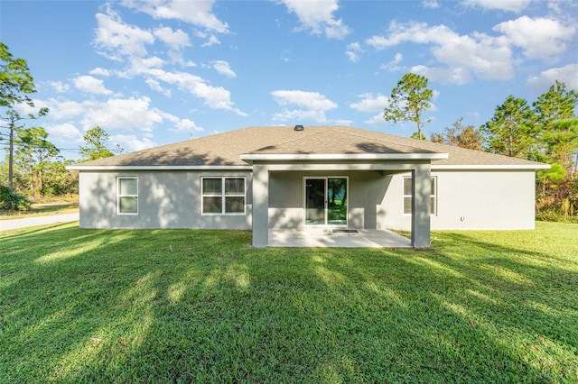 rear view of house featuring a patio area, stucco siding, and a yard