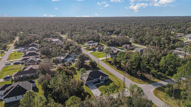 drone / aerial view with a wooded view and a residential view