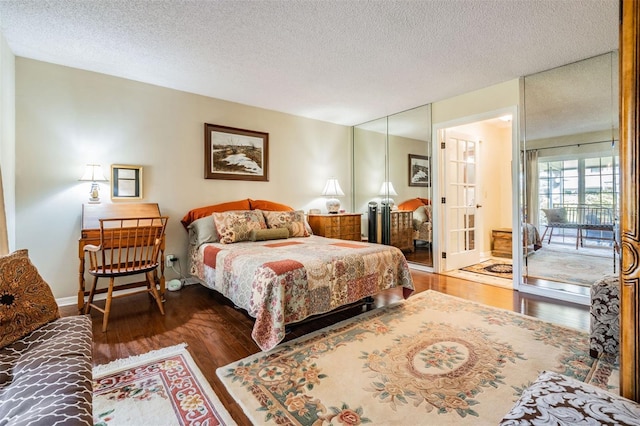 bedroom featuring a textured ceiling, baseboards, and wood finished floors