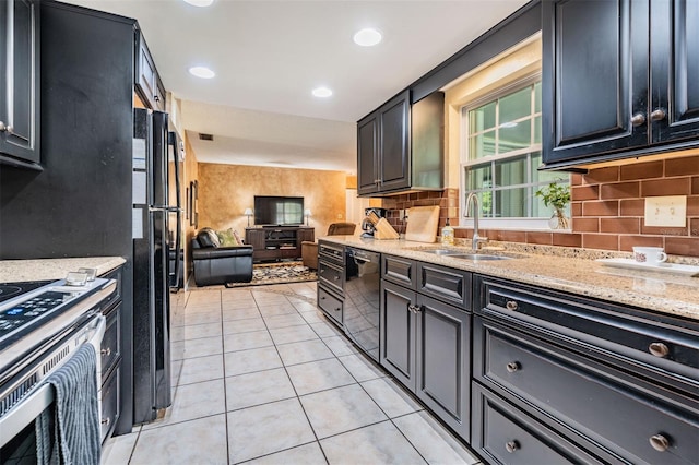 kitchen with light tile patterned floors, open floor plan, light stone countertops, black appliances, and a sink