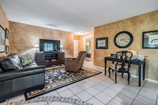 tiled living area with a textured ceiling and baseboards