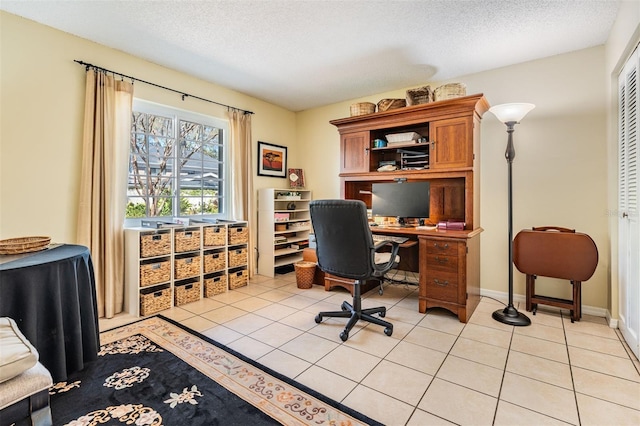 home office with a textured ceiling, baseboards, and light tile patterned floors