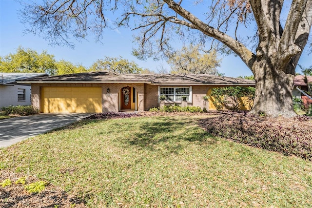 ranch-style home featuring a garage, driveway, brick siding, and a front yard