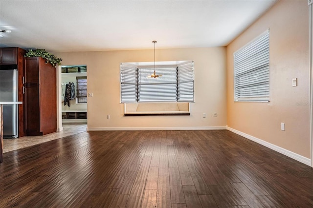 interior space featuring a wealth of natural light, baseboards, and dark wood-style flooring