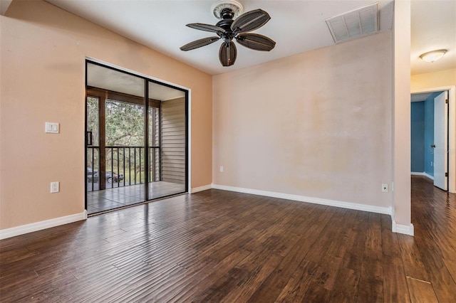 empty room with wood finished floors, visible vents, and baseboards