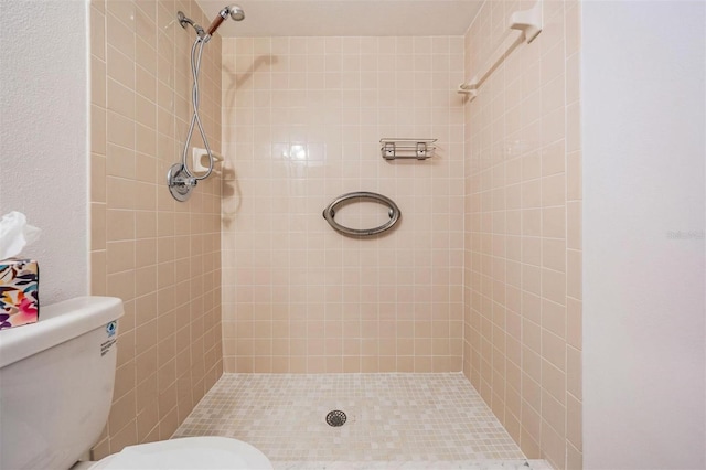 full bathroom with toilet and a tile shower