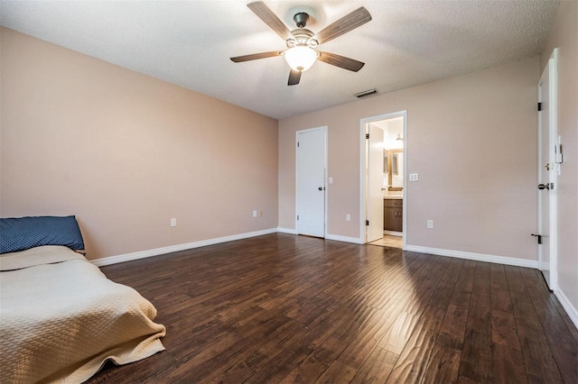 bedroom featuring wood-type flooring, connected bathroom, visible vents, and baseboards