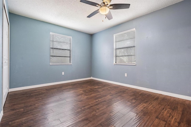 empty room with plenty of natural light, baseboards, ceiling fan, and dark wood-style flooring