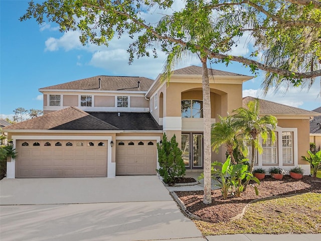 view of front facade featuring a garage, concrete driveway, and stucco siding