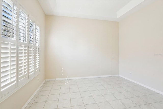 spare room with baseboards and light tile patterned flooring