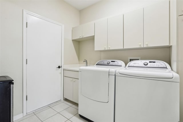laundry room featuring light tile patterned floors, a sink, cabinet space, and washer and dryer