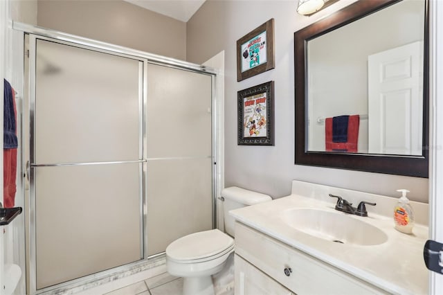 bathroom featuring vanity, a shower stall, toilet, and tile patterned floors