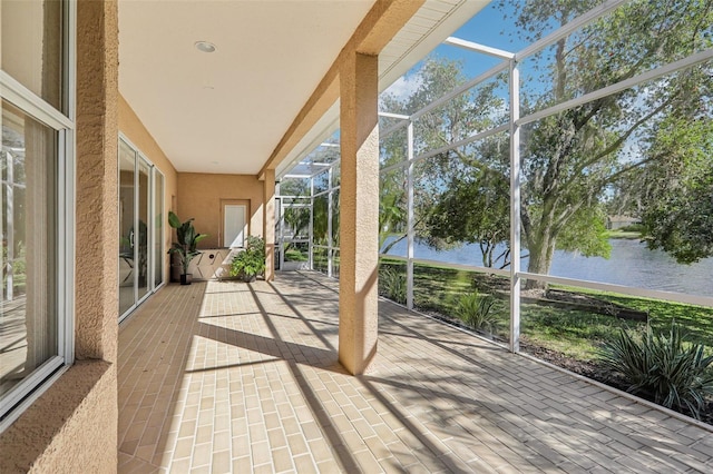 unfurnished sunroom featuring a water view