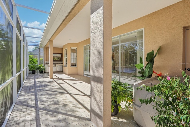 view of patio featuring exterior kitchen and a lanai