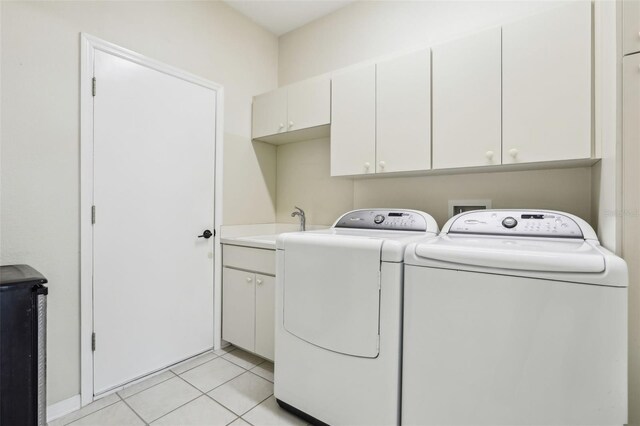 10211 Quails Landing Ave, Tampa, FL 33647 - clothes washing area featuring washing machine and dryer, cabinet space, and light tile patterned flooring