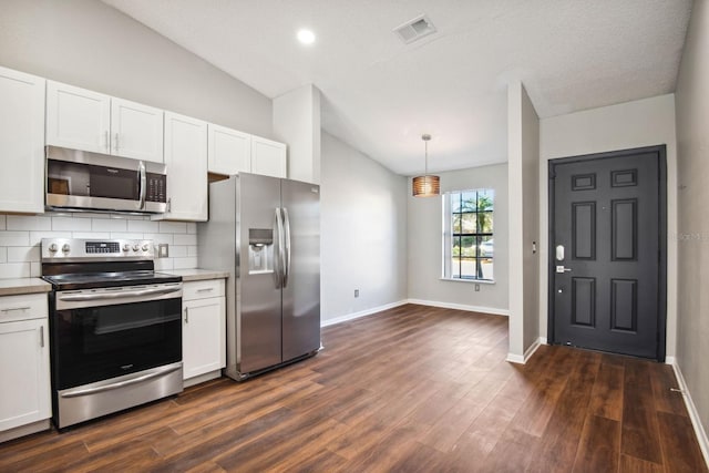 kitchen with stainless steel appliances, lofted ceiling, visible vents, decorative backsplash, and white cabinets