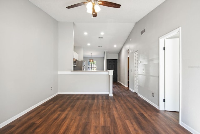 unfurnished living room featuring visible vents, baseboards, dark wood finished floors, a ceiling fan, and vaulted ceiling