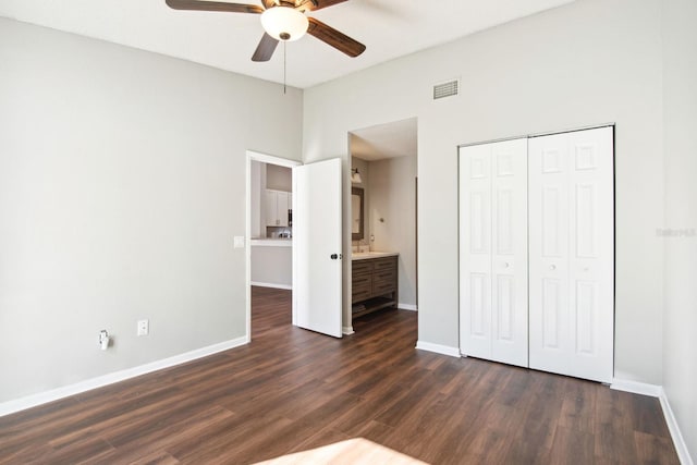 unfurnished bedroom featuring baseboards, a closet, visible vents, and dark wood-type flooring