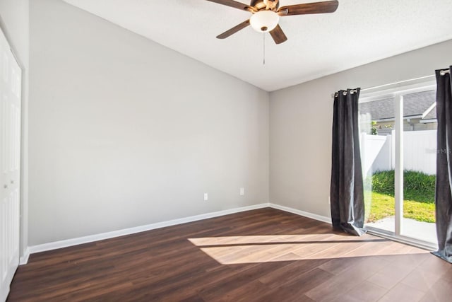 empty room with ceiling fan, baseboards, and wood finished floors