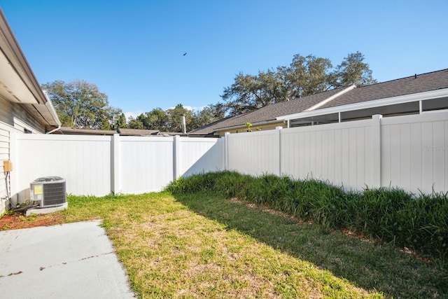 view of yard with central air condition unit and fence