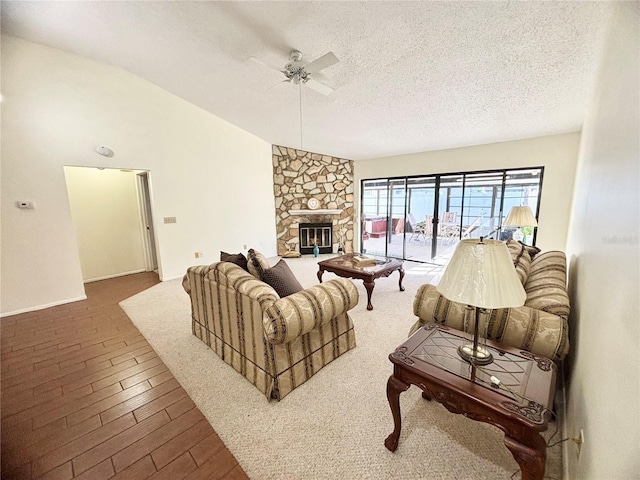 living room featuring a textured ceiling, a fireplace, wood finished floors, a ceiling fan, and vaulted ceiling