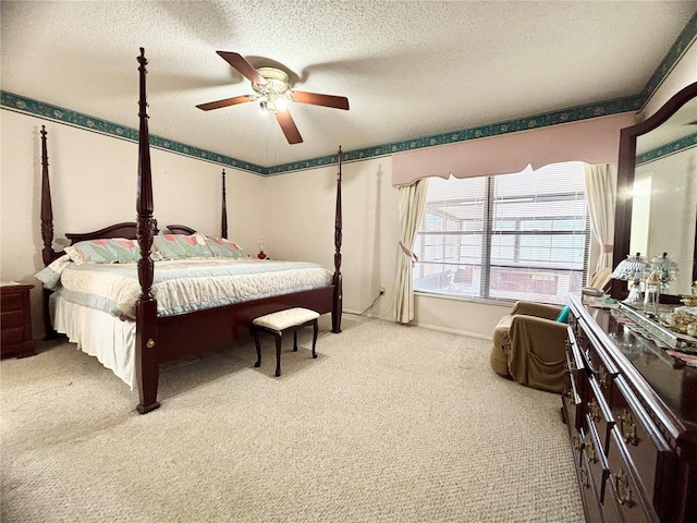 bedroom featuring ceiling fan, a textured ceiling, and light colored carpet