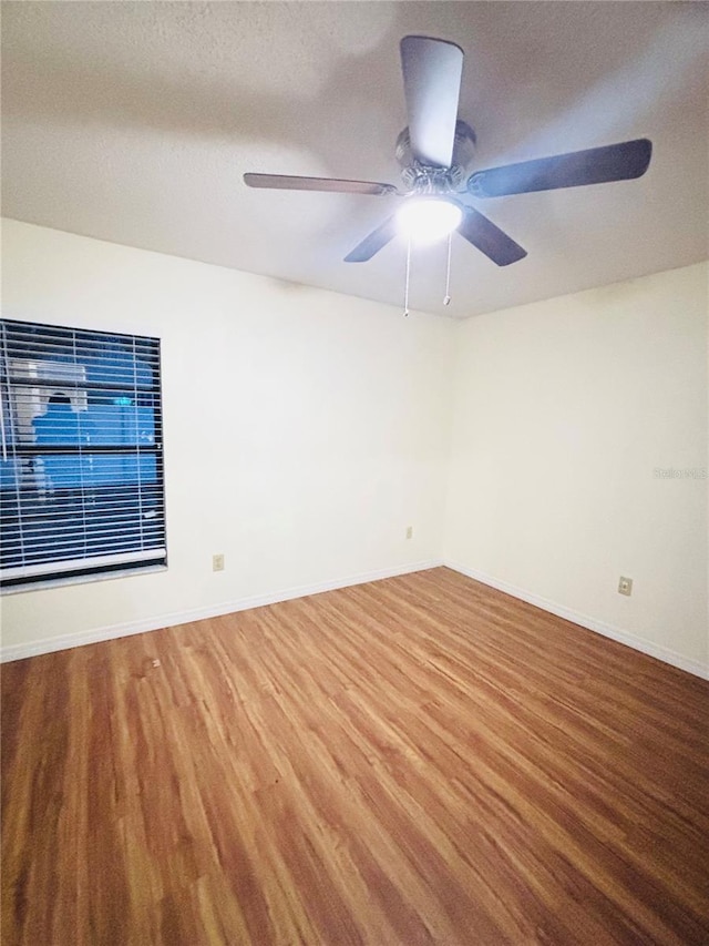 15013 Redcliff Dr, Tampa, FL 33625 - empty room with wood finished floors, a ceiling fan, baseboards, and a textured ceiling