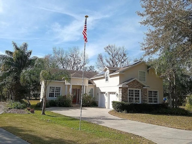 view of front of home with an attached garage, stone siding, driveway, stucco siding, and a front lawn