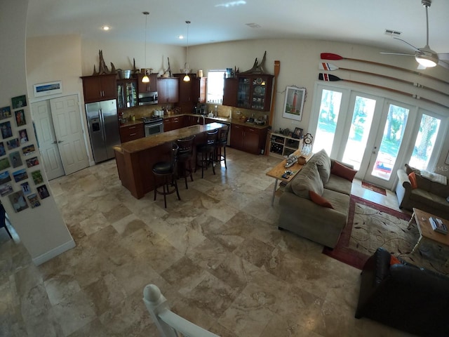 kitchen with visible vents, appliances with stainless steel finishes, a breakfast bar area, decorative light fixtures, and a center island