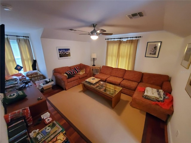 living area with a ceiling fan and visible vents