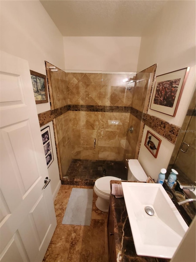 full bathroom with a stall shower, vanity, and toilet