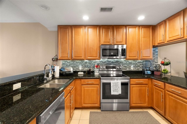 kitchen with visible vents, decorative backsplash, appliances with stainless steel finishes, light tile patterned flooring, and a sink