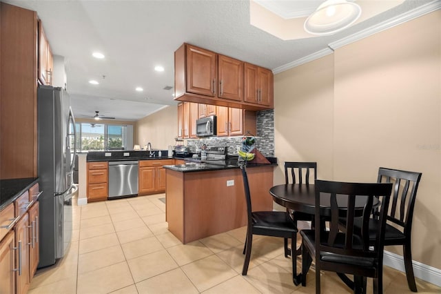 kitchen featuring light tile patterned flooring, a peninsula, appliances with stainless steel finishes, decorative backsplash, and crown molding