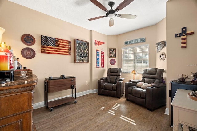 sitting room featuring ceiling fan, baseboards, and wood finished floors