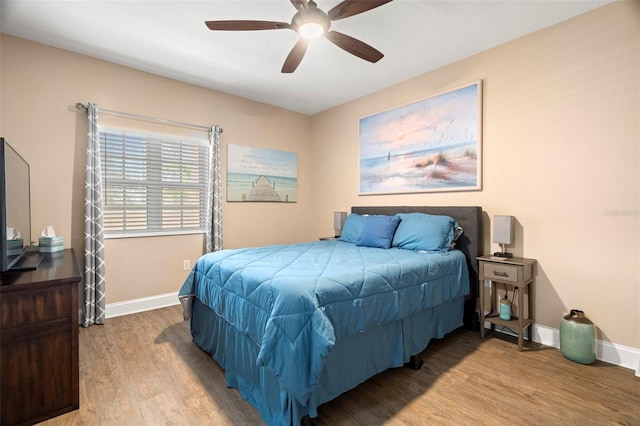 bedroom featuring a ceiling fan, baseboards, and wood finished floors