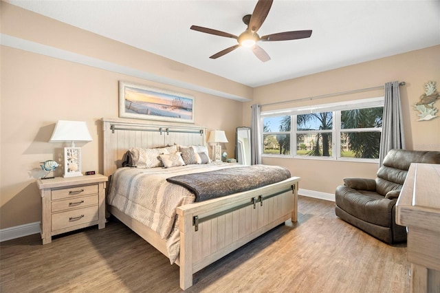 bedroom with wood finished floors, a ceiling fan, and baseboards