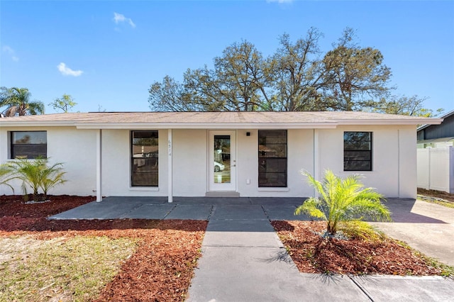 view of front of property featuring covered porch, fence, and stucco siding