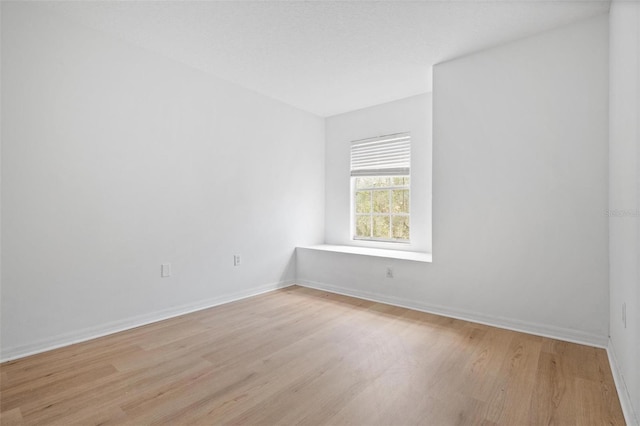 empty room featuring light wood-style flooring and baseboards