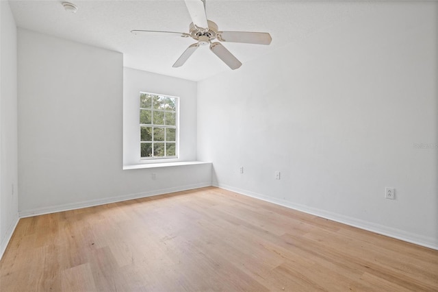 unfurnished room with light wood finished floors, baseboards, and a ceiling fan