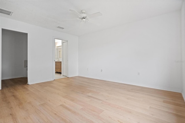 unfurnished bedroom featuring a walk in closet, baseboards, visible vents, and light wood finished floors