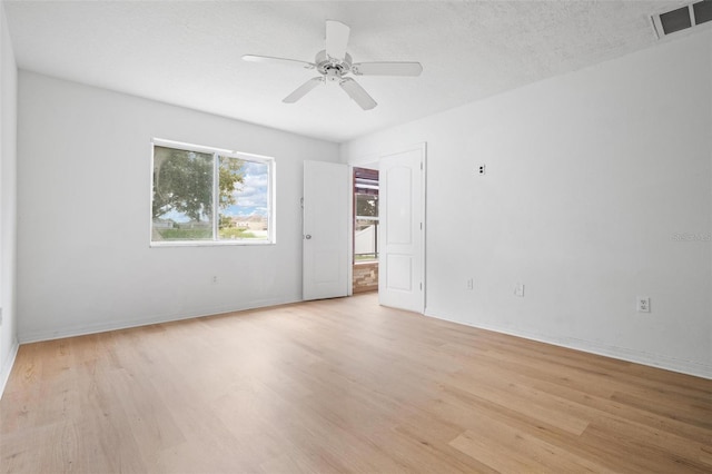 unfurnished room with a textured ceiling, visible vents, baseboards, a ceiling fan, and light wood-type flooring