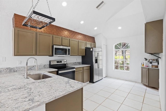 kitchen featuring lofted ceiling, light stone counters, stainless steel appliances, a sink, and visible vents