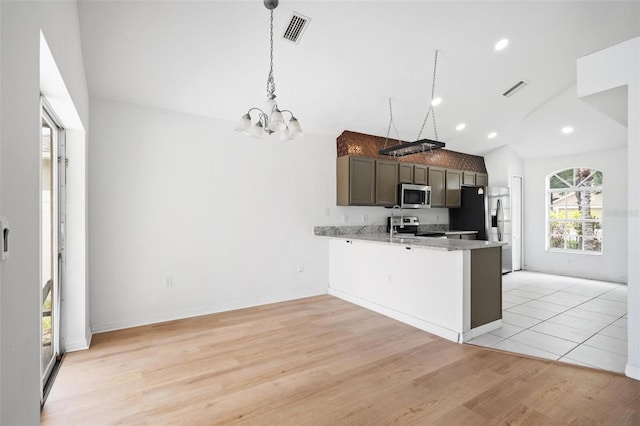 kitchen with a peninsula, light wood finished floors, visible vents, and stainless steel appliances