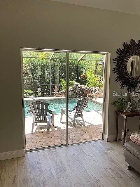 doorway to outside with baseboards and wood finished floors