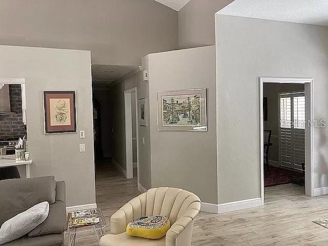 hallway featuring light wood-type flooring and baseboards